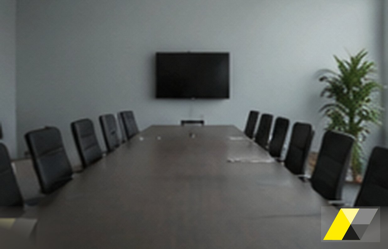 Tre professionisti intorno a un tavolo esaminano documenti aziendali durante un risk assessment