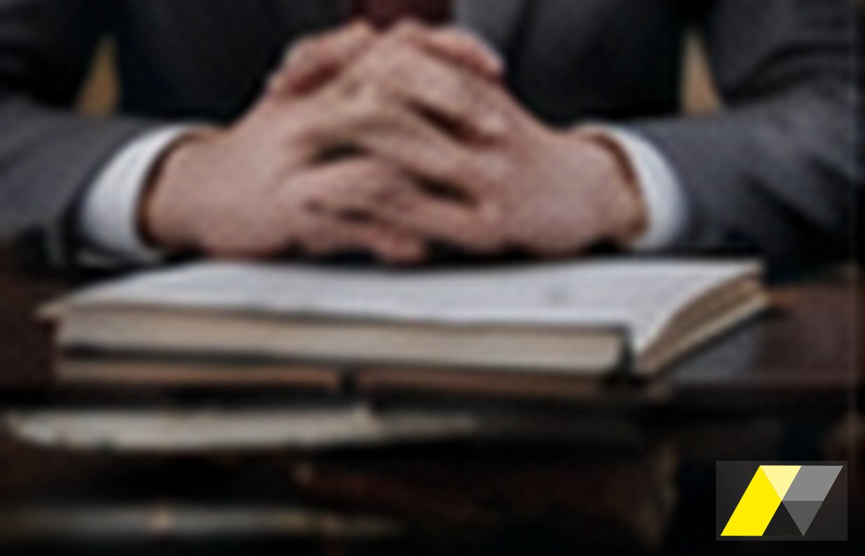 Professionista con le mani giunte su un quaderno aperto: difesa per infortunio sul lavoro, Soardi Studio Legale